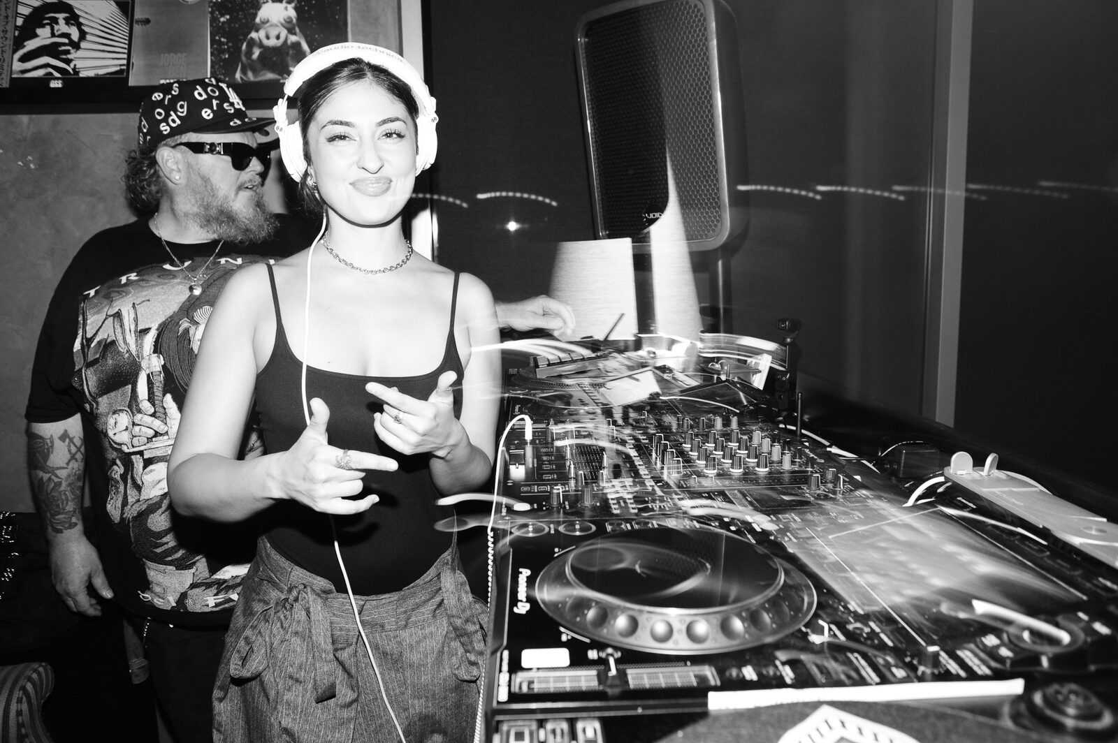 A DJ in headphones smiling behind the decks in the Stereo 41 lounge