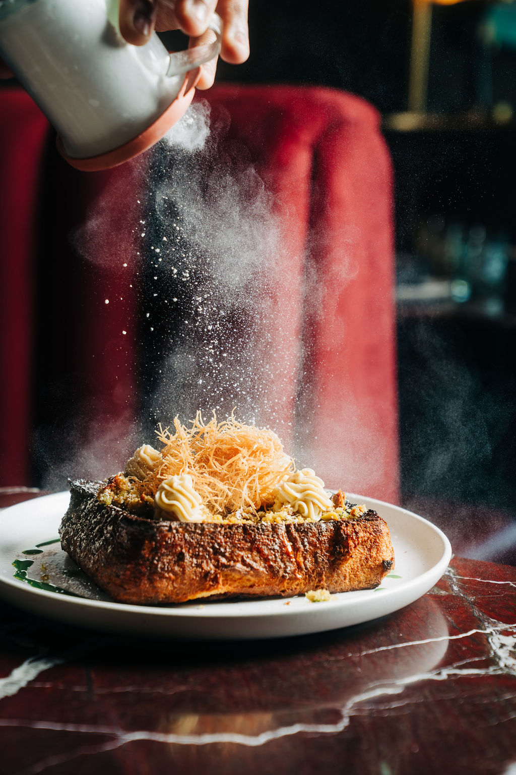 Powdered sugar falling through the air onto french toast