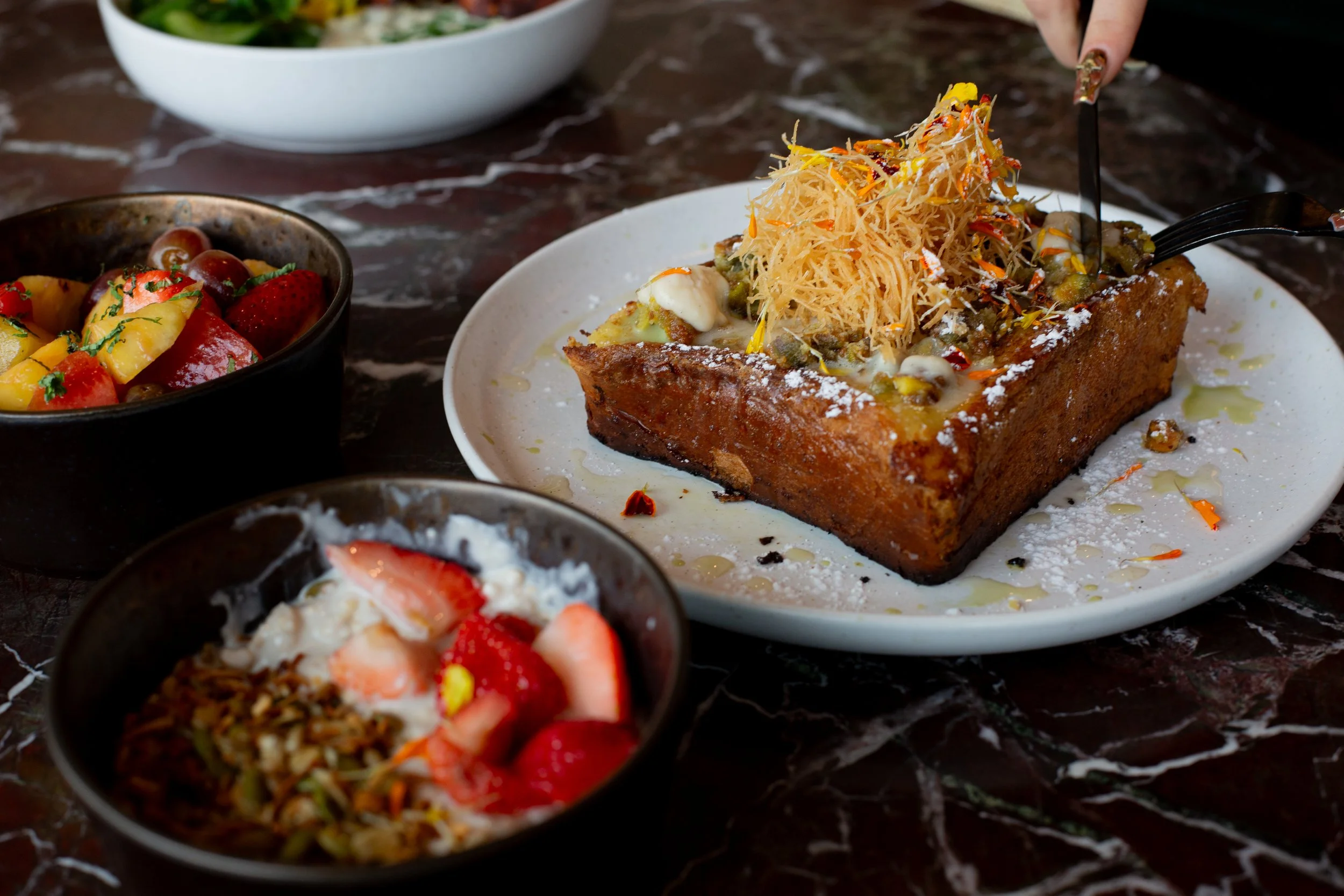 French toast with pistachio spread and a yogurt bowl with fruit and nuts