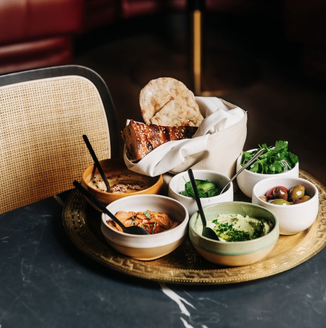 Mezze platter featuring olives, baba ganoush, and hummus