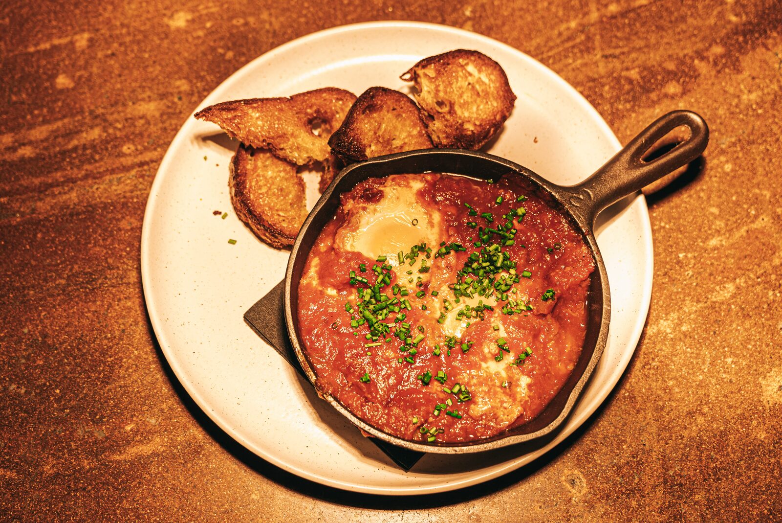 Eggs in Purgatory skillet with toasted bread - Creole brunch Walnut Creek