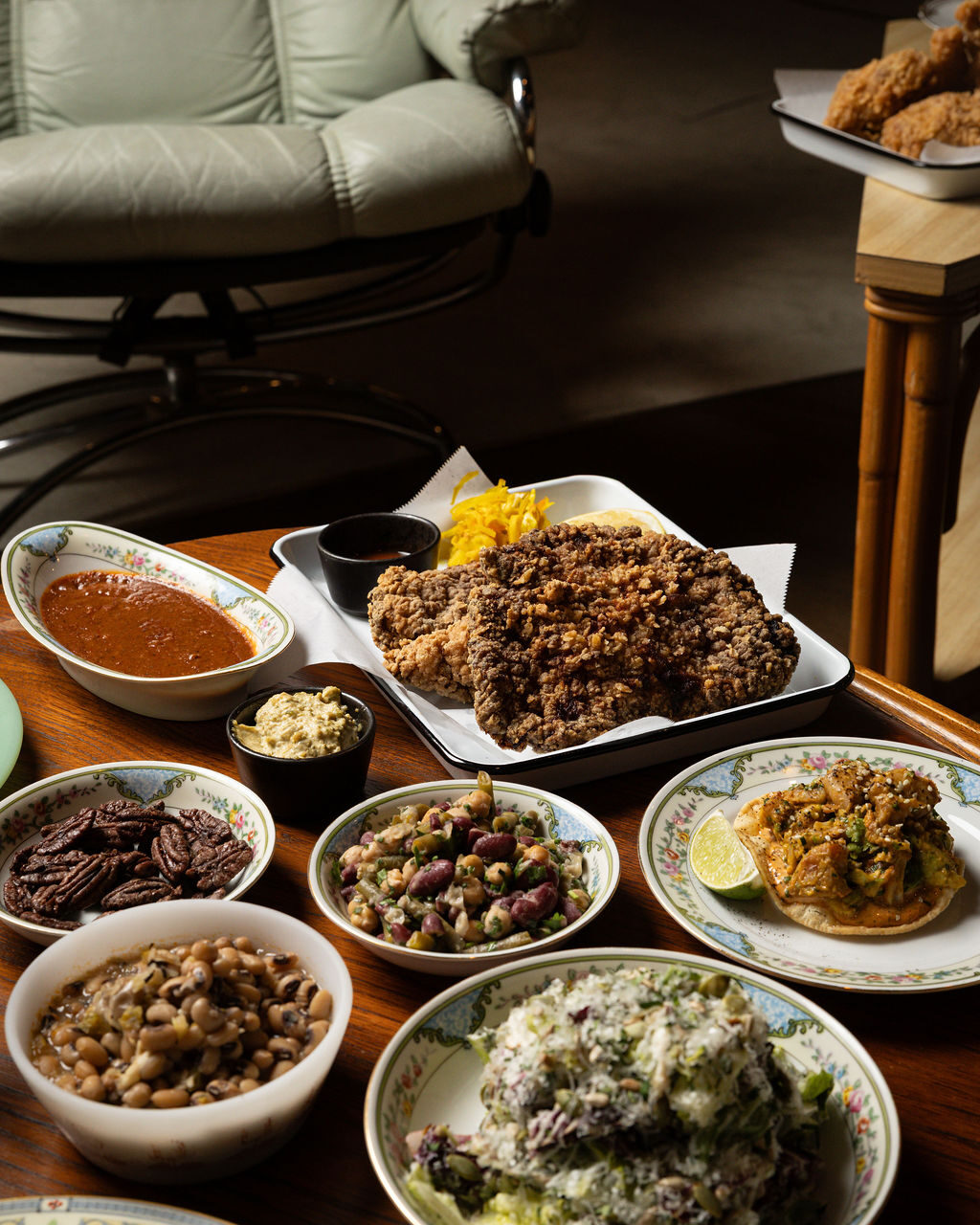 Chicken fried steak with black-eyed peas, candied pecans, and Southern sides on vintage china